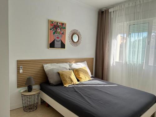 BeniarbeigCasa Feliz的卧室内的一张带两个枕头和镜子的床