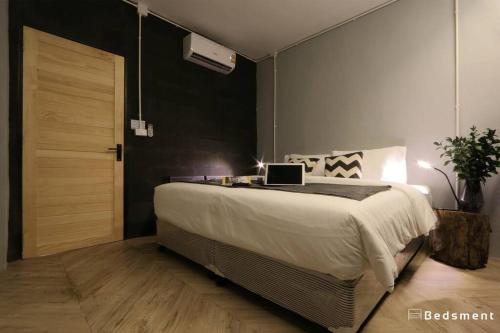 清莱Bedsment@Hayaek的一间卧室配有一张带笔记本电脑的床