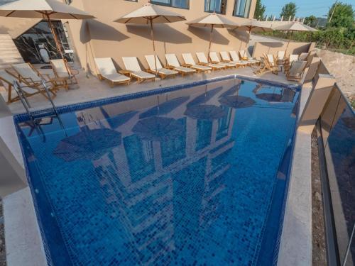 多布拉沃达Hotel Diman的一个带椅子和遮阳伞的游泳池