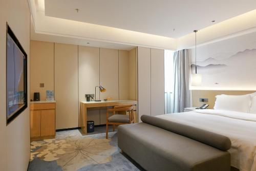 深圳柏高酒店（深圳罗湖口岸店）的配有一张床和一张书桌的酒店客房