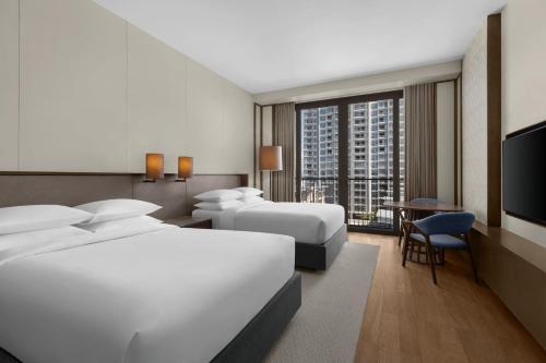 麦克坦Sheraton Cebu Mactan Resort的酒店客房设有两张床和电视。
