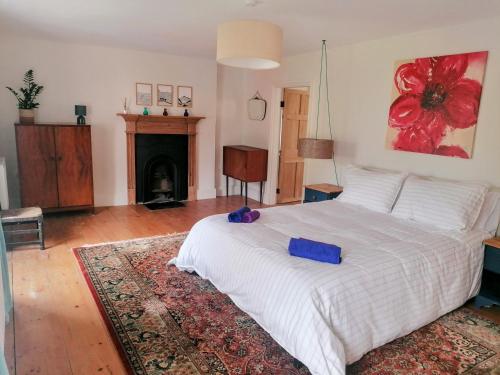 GwynfeBryn Capel, Gwynfe的卧室配有白色的床和壁炉
