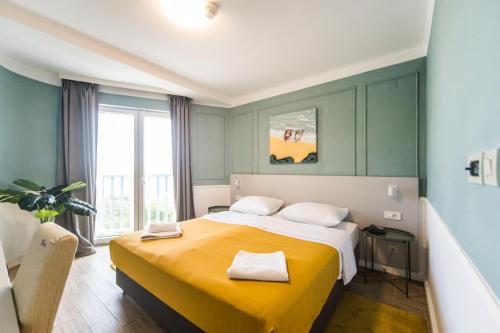 帕格广场酒店的一间卧室配有一张带黄色毯子的大床
