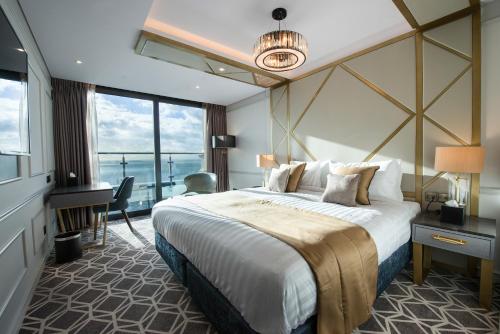滨海绍森德赛文酒店的酒店客房设有一张大床和一张书桌。