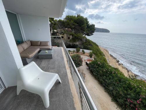 莫莱拉Sea front, design, Air Conditioning, heating, First floor, 4beds的俯瞰大海的阳台配有白色椅子和沙发