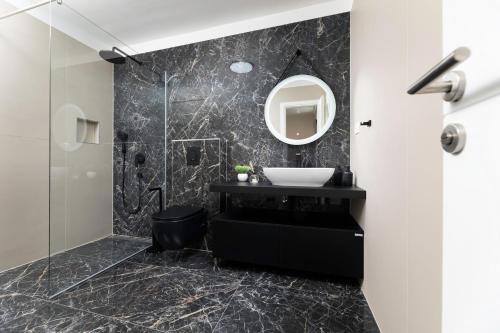 科里米诺Villa Terra Bianca的黑色浴室设有水槽和镜子