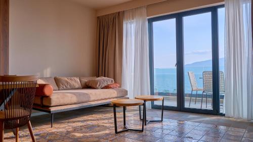 伏罗拉Azar Luxury Suites的带沙发和大窗户的客厅