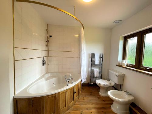 葛特纳格林Pass the Keys Spectacular 7BR House Hot Tub and Gardens in Gretna的一间带大浴缸和卫生间的浴室