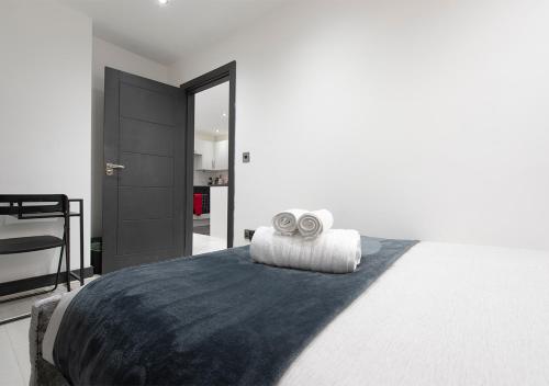 伦敦1 Bedroom Apartment Near Brick Lane的一间卧室配有一张床,上面有两条毛巾