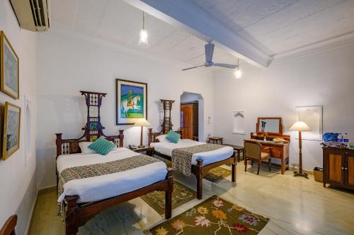 瓜廖尔尼姆拉纳斯 - 迪奥巴格酒店的一间卧室配有两张床、一张桌子和一张书桌