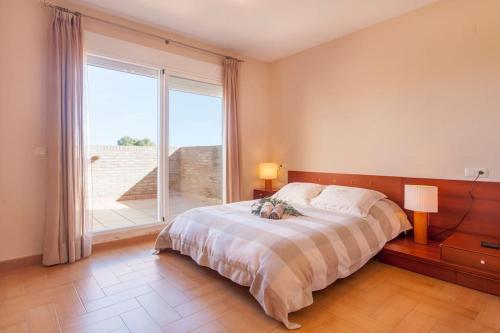 瓦伦西亚Casa en Valencia, cerca de golf, playas, moto Gp的一间卧室设有一张床和一个大窗户