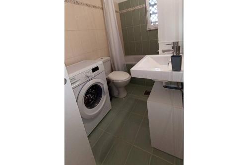 扎金索斯镇Bougainvillea apartment的一间带洗衣机和水槽的浴室