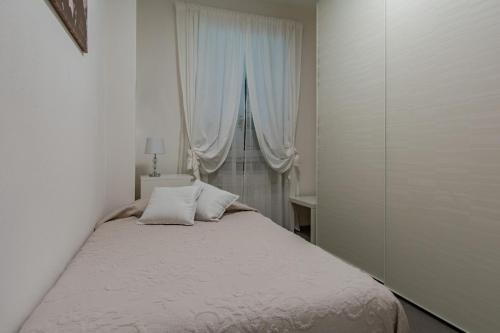 马里纳迪马萨La passione al mare的一间卧室配有一张带白色床单的床和一扇窗户。