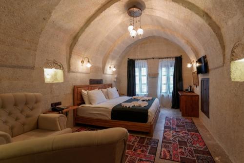 格雷梅Göreme Escape Cave Suites的一间卧室配有一张床和一个沙发