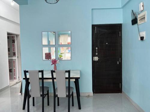 孟买Angel Views 101, Chapel Road, Bandra West by Connekt Homes的一间拥有蓝色墙壁和桌椅的用餐室
