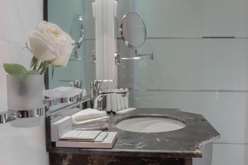 巴哈Cloud City Hotel فندق مدينة السحاب的一间带水槽、镜子和玫瑰的浴室