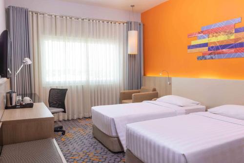 达沃市达沃丽柏酒店的酒店客房配有两张床和一张书桌