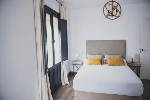 埃希哈Apartamento La Milagrosa的卧室配有一张带黄色枕头的大型白色床。