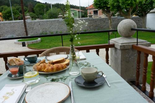 库迪列罗Hotel El Rosal de Cudillero的一张桌子,上面放着一盘面包和一杯咖啡