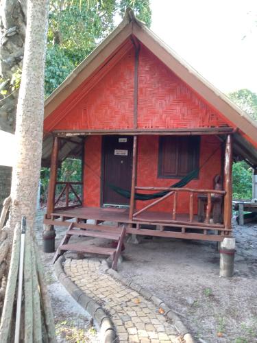 高兰Andaman Bay House的一间红色的小小屋,前面设有野餐桌