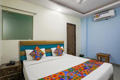 ChinhatFabHotel SM Palace的一间卧室配有一张大床和色彩缤纷的毯子