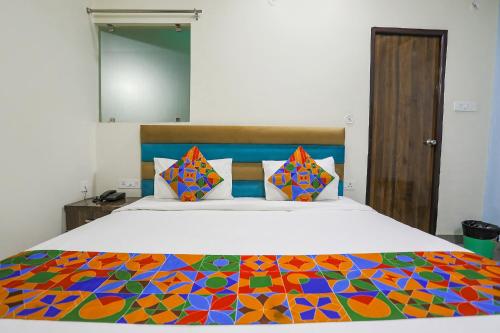 ChinhatFabHotel SM Palace的一间卧室配有一张带五颜六色棉被的床