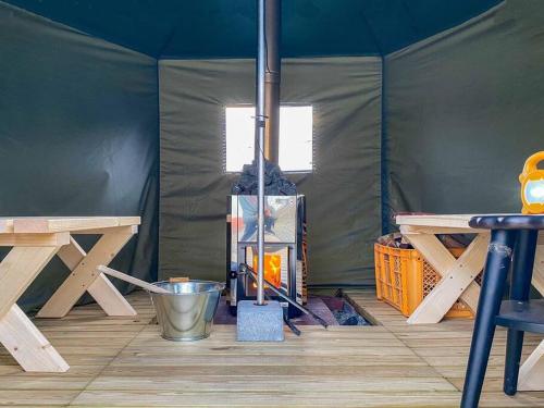 洞爷湖THE BLAUBAUM TOYA的帐篷,配有两张野餐桌和一桶