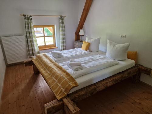 弗拉斯多夫Seeberghof的卧室配有一张带白色床单和枕头的大床。
