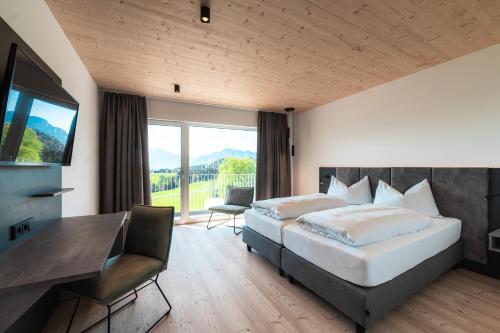 蒙德塞Landhotel Prielbauer的一间卧室配有一张床、一张书桌和一台电视