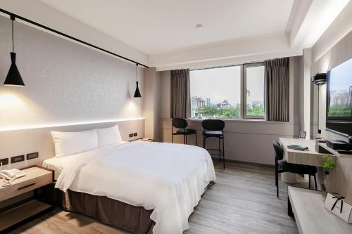 台北多郎明哥商务旅馆的配有一张床和一张书桌的酒店客房