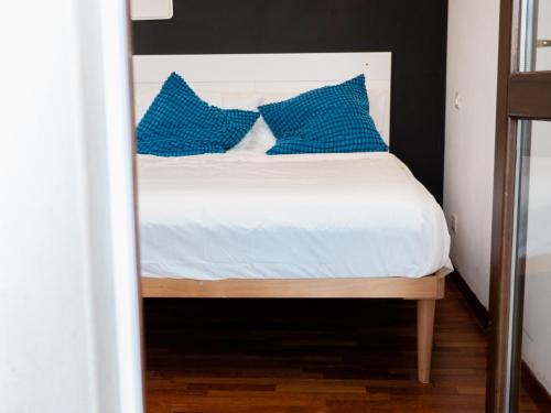 佩斯卡拉Minià的一间卧室配有一张带蓝色枕头的床