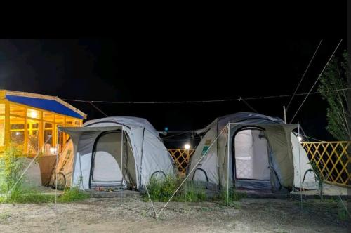 GulmitBaseet Camping and Restaurant的一群帐篷在晚上在田野里