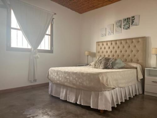 圣卡洛斯La Puerta Azul San Carlos的一间卧室设有一张大床和大窗户