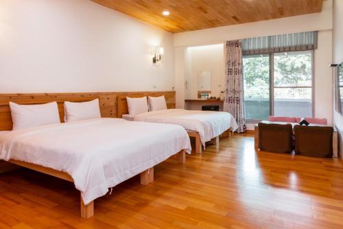 Yung-an-ts'un后山人家民宿A馆的铺有木地板的客房内的两张床