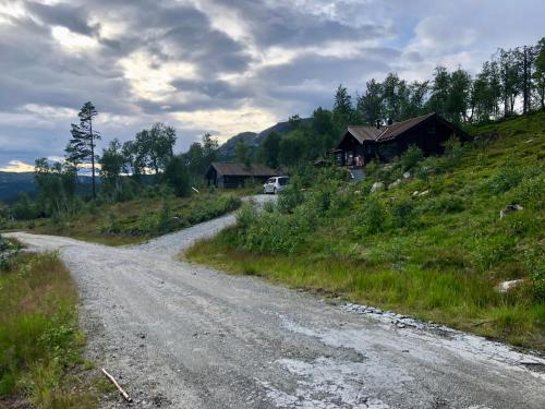 弗洛Hytte på Sørbølfjellet的山坡上房子旁边的土路