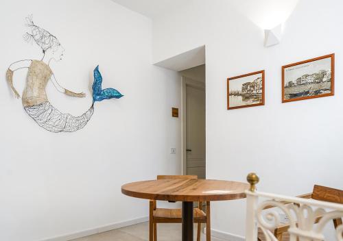 马达莱纳Ad Oriente的一间设有桌子和墙上绘画的用餐室