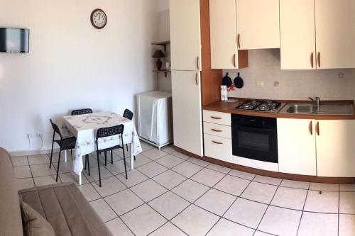 马里蒂玛Salento_Cala Acquaviva a Marina di Marittima (LE)的厨房配有桌子、水槽和冰箱