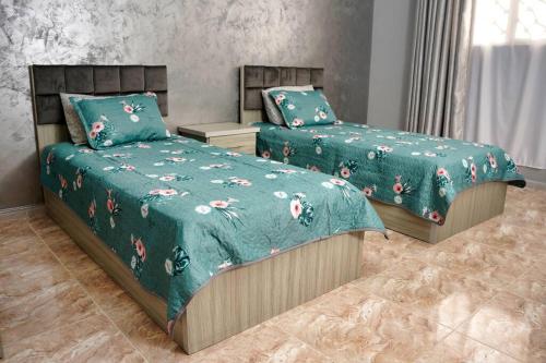 瓦迪穆萨Treasure of Petra的一间卧室配有两张带绿色棉被的床