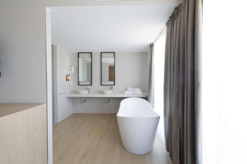 坎加斯德穆拉索Hotel H4 Cangas 3 Superior的白色的浴室设有水槽和镜子