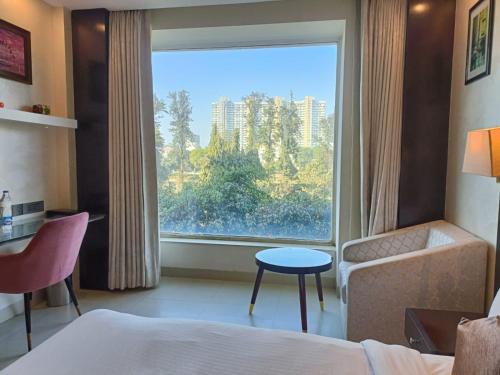 新德里Udman Hotel Chhattarpur的酒店客房设有一张床和一个大窗户