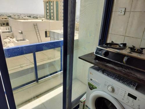 沙迦Prem Home Stay的带窗户的客房内的洗衣机