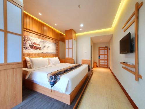 日惹Little Tokyo的一间卧室配有一张大床和一台平面电视