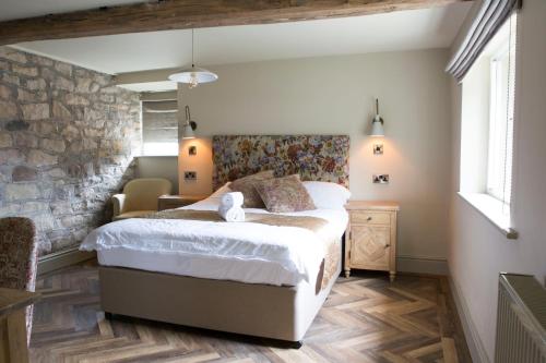 Two DalesSquare & Compass的一间卧室设有一张床和石墙