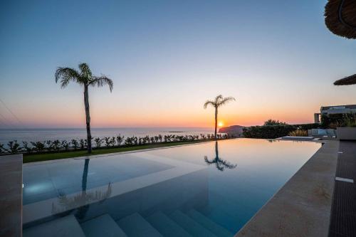 法拉萨纳Cielo e Mare Villas的日落时分享有海洋美景的游泳池
