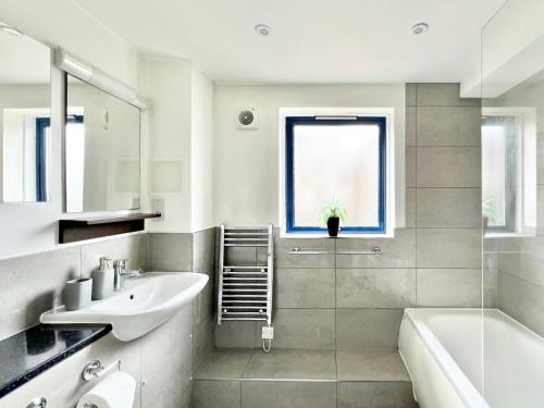 伦敦WEEKLY OR MONTHLY STAY - Relocation & Business - 4 Guests - By Hofin Stays Short Lets & Serviced Accommodation的白色的浴室设有水槽、浴缸和水槽。