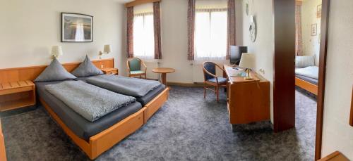 ErlbachWohlfühlherberge Weitblick的酒店客房带一张床铺、一张书桌和一间卧室