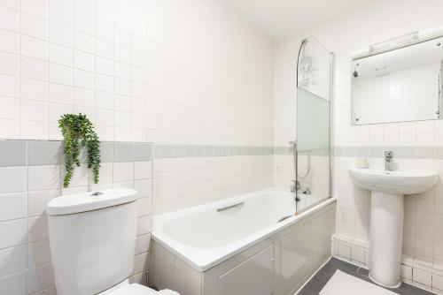 伦敦The Highbury Collection的白色的浴室设有水槽、卫生间和浴缸。