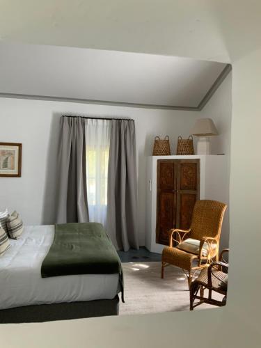 博尼约Le Mas Les Eydins的卧室配有床、椅子和窗户。