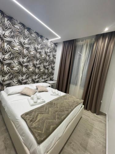 罗马Bobbio Holiday Rome的卧室配有一张白色大床和一堵墙