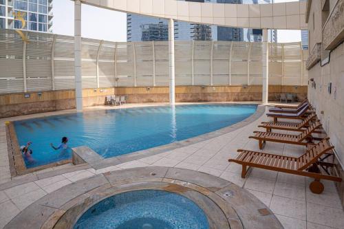 阿布扎比Your Luxurious 2BR Al Reem Escape at Mangrove Place的一座大型游泳池,其中有2人